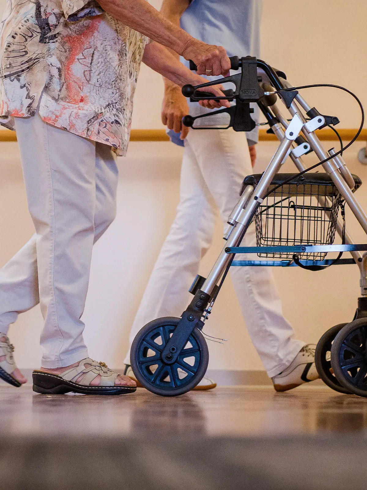 ARCHIV - 23.08.2018, Stuttgart: Eine Pflegekraft geht in einem Pflegeheim mit einer älteren Dame über einen Korridor. (zu dpa «AOK-Zahlen zur Pflege in Rheinland-Pfalz») Foto: Christoph Schmidt/dpa +++ dpa-Bildfunk +++