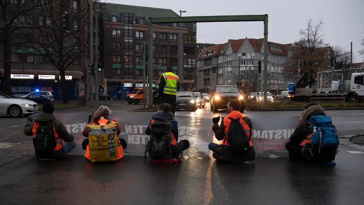 24.01.2022, Berlin: Aktivisten einer Gruppe, die sich Aufstand der letzten Generation nennt, blockieren in Steglitz die Zufahrt zur Stadtautobahn. Klimaschützer haben am Morgen versucht, Straßen in Berlin zu blockieren. Sie fordern von der Bundesregierung ein Gesetz gegen Lebensmittelverschwendung und Entscheidungen für eine verträglichere Landwirtschaft. Foto: Paul Zinken/dpa +++ dpa-Bildfunk +++