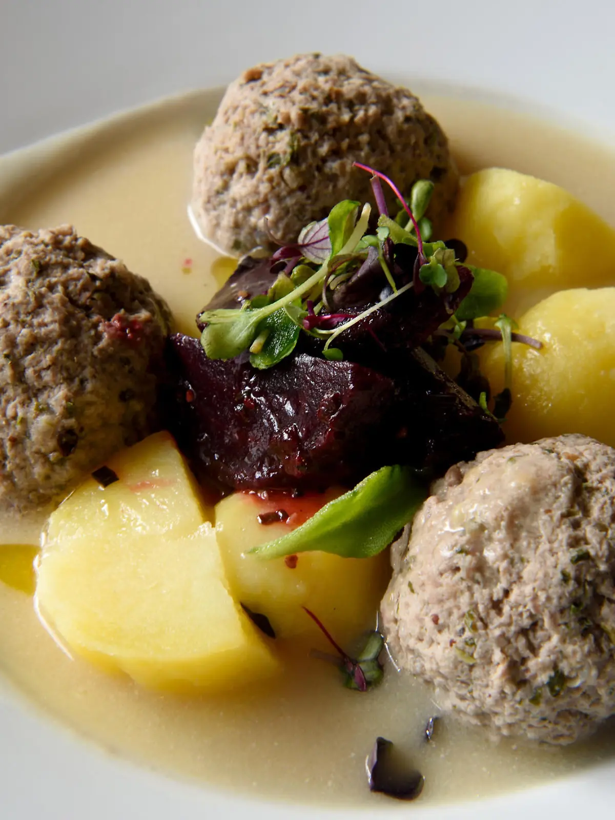 Prussian specialty of Konigsberger Klopse boiled meatballs in a white sauce with anchovy, young potatoes, capers and beet root.