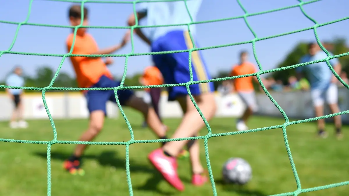 SYMBOLBILD - 05.06.2016, Baden-Württemberg, Mannheim: Kinder spielen auf einem Sportplatz der Konrad-Duden-Schule beim Start der Straßenfußball-WM 2016. (zu dpa: «Ministerium sagt Sportvereinen finanzielle Unterstützung zu») Foto: Uwe Anspach/dpa +++ dpa-Bildfunk +++