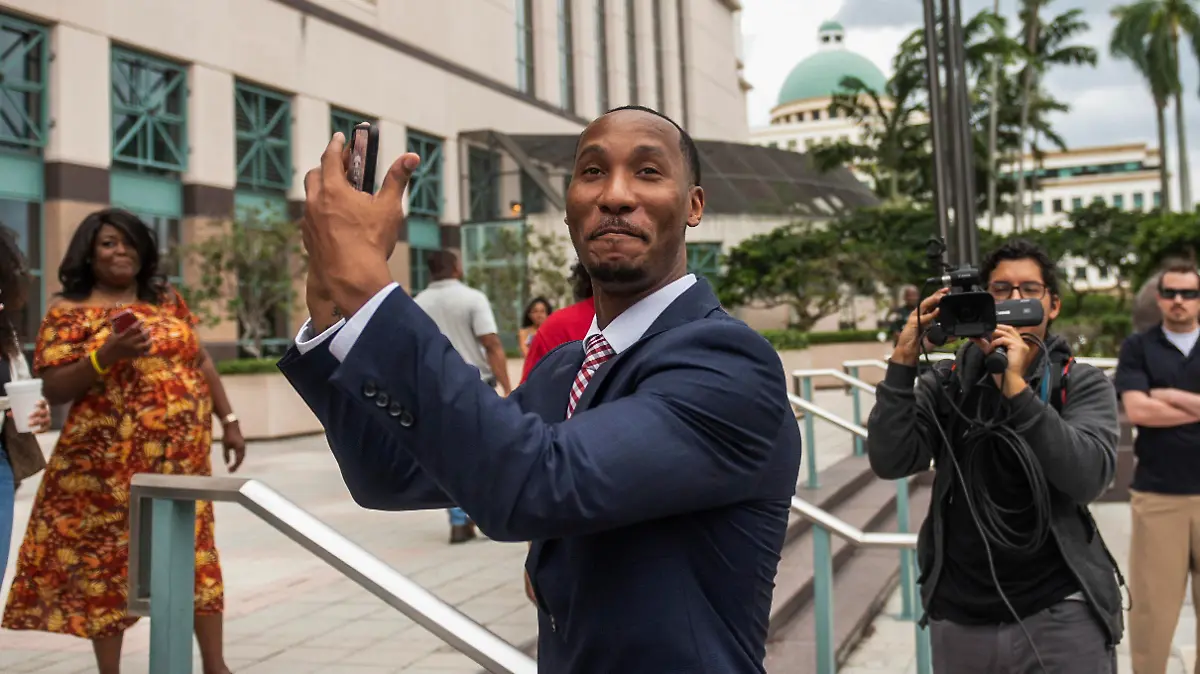 Travis Rudolph mimes catching a football while standing on the steps of the Palm Beach County Courthouse after a jury acquitted him of all charges in a fatal shooting in 2021, Wednesday, June 7, 2023, in West Palm Beach, Fla. (Andres Leiva/The Palm Beach Post via AP)
