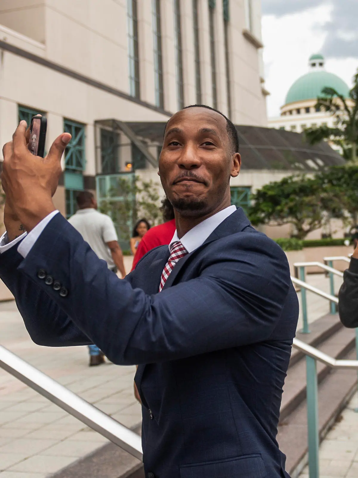 Travis Rudolph mimes catching a football while standing on the steps of the Palm Beach County Courthouse after a jury acquitted him of all charges in a fatal shooting in 2021, Wednesday, June 7, 2023, in West Palm Beach, Fla. (Andres Leiva/The Palm Beach Post via AP)