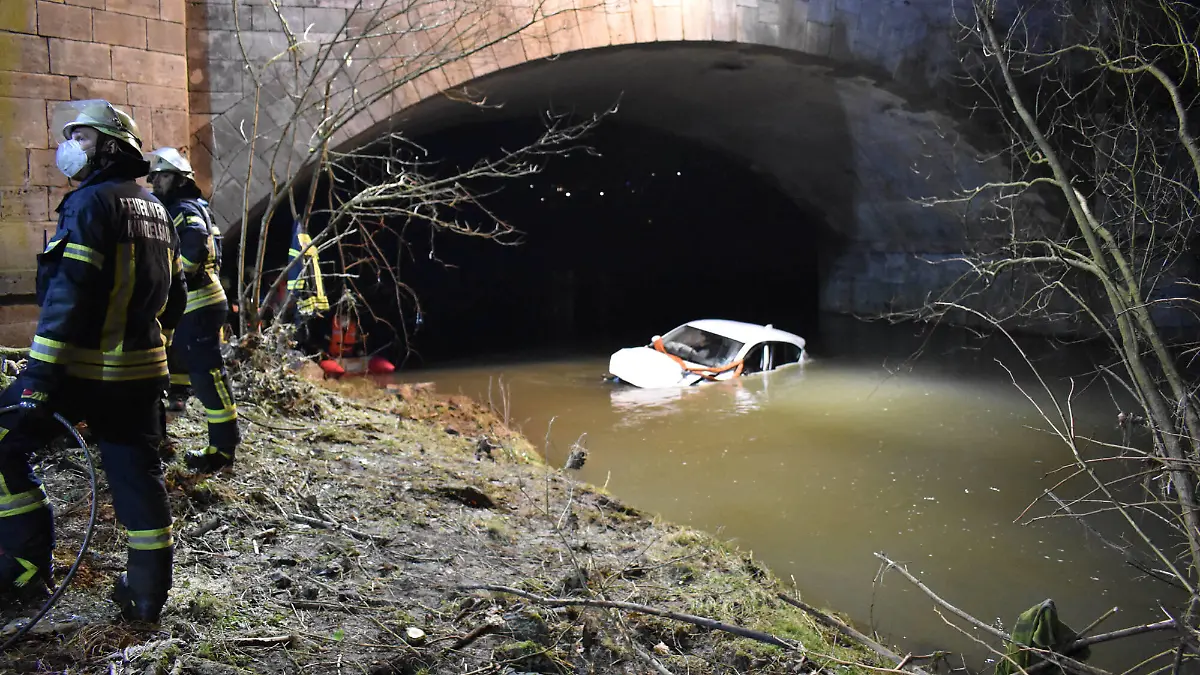 Auto stürzt Brücke in Bach hinab, 12.02.2022, Baden-Württemberg, Künzelsau: Ein PKW liegt unterhalb einer Brücke an der Haller Straße im Fluss Kocher. Zuvor war das Fahrzeug mitsamt dem Fahrer von der Straße abgekommen und rund vier Meter in das Gewässer gestürzt. Die Feuerwehr barg das Fahrzeug. Künzelsau Baden-Württemberg Deutschland Künzelsau Copyright: x xonw-imagesx/xFabianxKossx