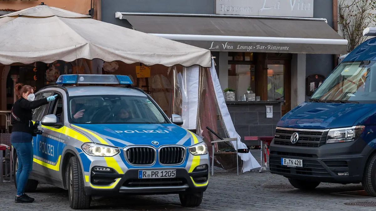 13.02.2022, Bayern, Weiden In Der Oberpfalz: Polizeifahrzeuge stehen vor einem Lokal in der Innenstadt. Nach einem Restaurantbesuch ist ein 52-Jähriger möglicherweise an einer Vergiftung gestorben. Sieben weitere Personen seien verletzt worden, einige sogar schwer, teilte die Polizei am Sonntag mit. Foto: Armin Weigel/dpa +++ dpa-Bildfunk +++