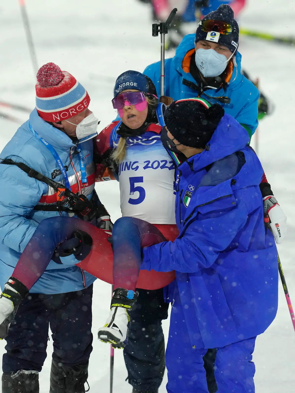 Ingrid Landmark Tandrevold of Norway is helped off the track after the women's 10-kilometer pursuit race at the 2022 Winter Olympics, Sunday, Feb. 13, 2022, in Zhangjiakou, China. (AP Photo/Kirsty Wigglesworth)