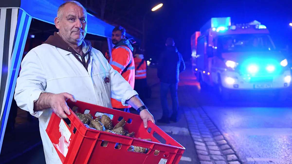 14.02.2022, Bayern, Schäftlarn: Metzger Ingo Ruber hält eine Kiste mit Semmeln, die er für die Einsatzkräfte bereitgestellt hat. Beim Zusammenstoß zweier S-Bahnen im Landkreis München sind am Montag ein Mensch getötet und mehr als zehn verletzt worden. Es habe eine niedrige zweistellige Zahl an Verletzten gegeben, berichtete ein Sprecher des Münchner Polizeipräsidiums. Foto: Lennart Preiss/dpa +++ dpa-Bildfunk +++