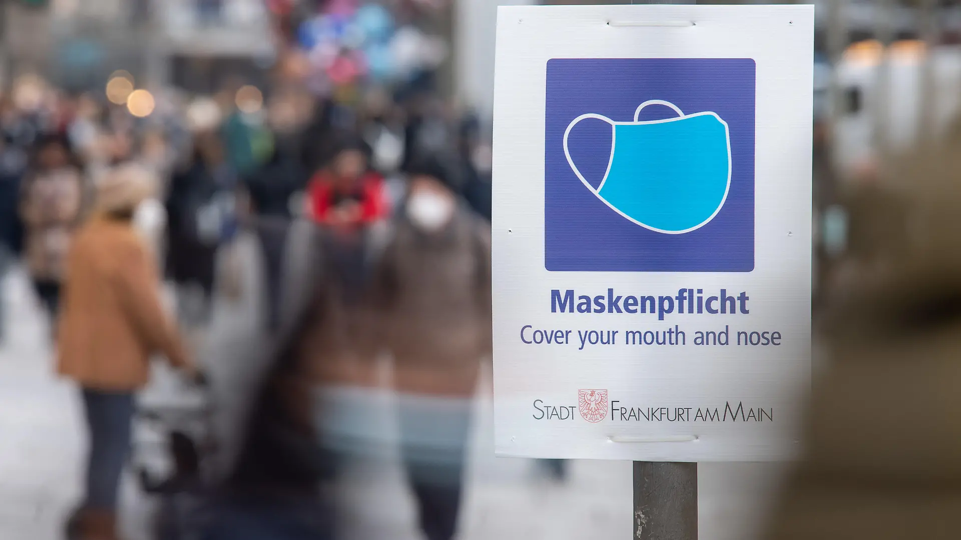 ARCHIV - 17.01.2022, Hessen, Frankfurt/Main: Ein Schild weist auf der Einkaufsstraße Zeil auf die Maskenpflicht hin. Eine wohl noch leichter übertragbare Untervariante von Omikron könnte aus Expertensicht zu einer Verlängerung der derzeitigen Infektionswelle führen. (zu dpa «Experte: Omikron-Subtyp BA.2 könnte Omikron-Welle verlängern») Foto: Sebastian Gollnow/dpa +++ dpa-Bildfunk +++
