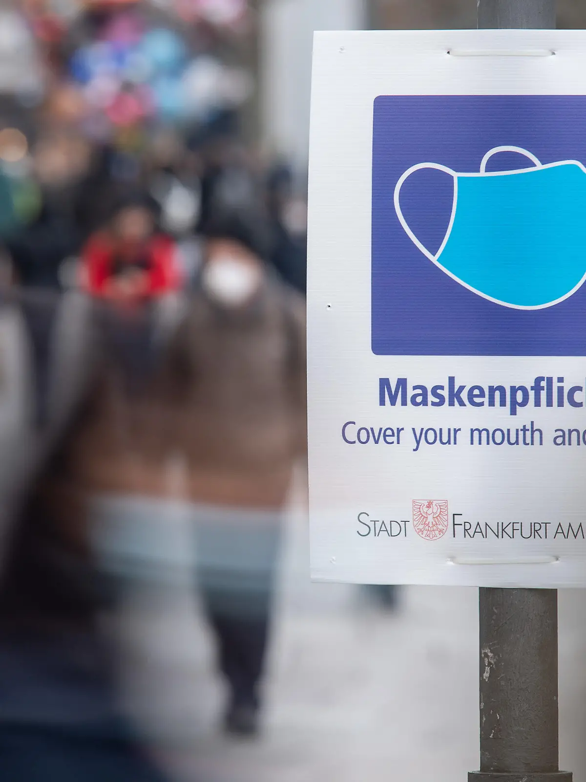 ARCHIV - 17.01.2022, Hessen, Frankfurt/Main: Ein Schild weist auf der Einkaufsstraße Zeil auf die Maskenpflicht hin. Eine wohl noch leichter übertragbare Untervariante von Omikron könnte aus Expertensicht zu einer Verlängerung der derzeitigen Infektionswelle führen. (zu dpa «Experte: Omikron-Subtyp BA.2 könnte Omikron-Welle verlängern») Foto: Sebastian Gollnow/dpa +++ dpa-Bildfunk +++