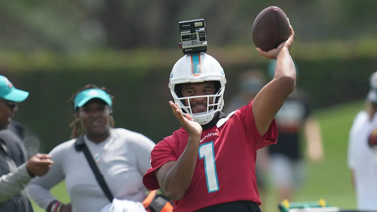 Miami Dolphins quarterback Tua Tagovailoa (1) throws passes with a camera mounted on his helmet during NFL football practice, Thursday, June 8, 2023, in Miami Gardens, Fla. (AP Photo/Jim Rassol)