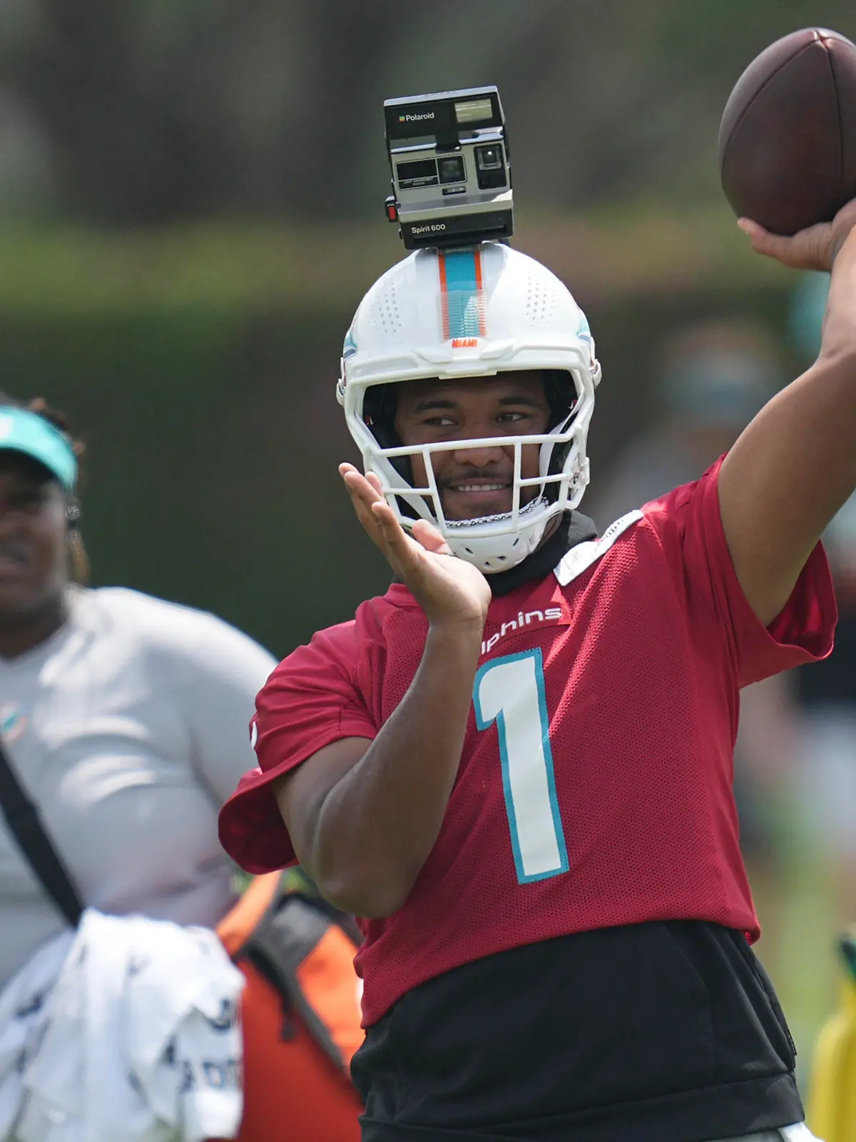 Miami Dolphins quarterback Tua Tagovailoa (1) throws passes with a camera mounted on his helmet during NFL football practice, Thursday, June 8, 2023, in Miami Gardens, Fla. (AP Photo/Jim Rassol)