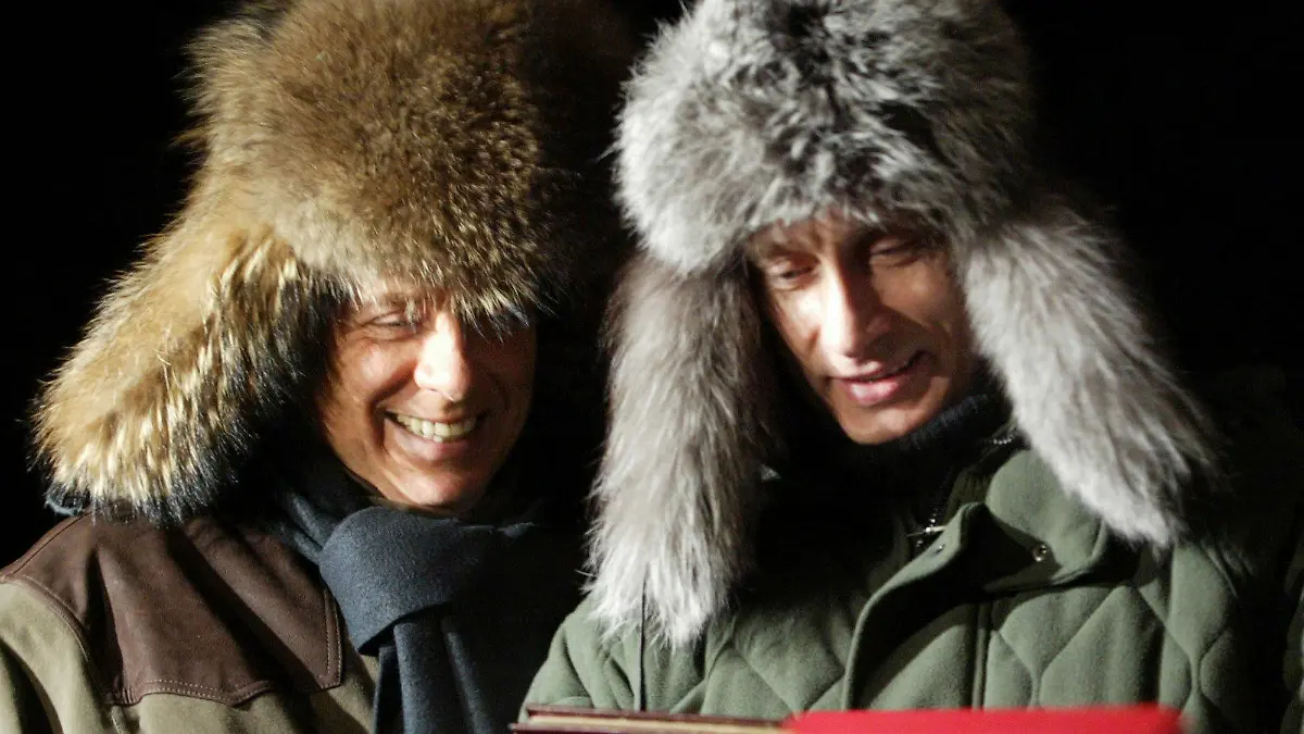 FILE - Russian President Vladimir Putin, right, presents a book about his rural lodge Zavidovo to former Italian Prime Minister Silvio Berlusconi in Zavidovo, about 120 kilometers (75 miles) northwest of Moscow, on Feb. 3, 2003. Berlusconi, the boastful billionaire media mogul who was Italy's longest-serving premier despite scandals over his sex-fueled parties and allegations of corruption, died, according to Italian media. He was 86. (AP Photo/Viktor Korotayev, Pool, File)