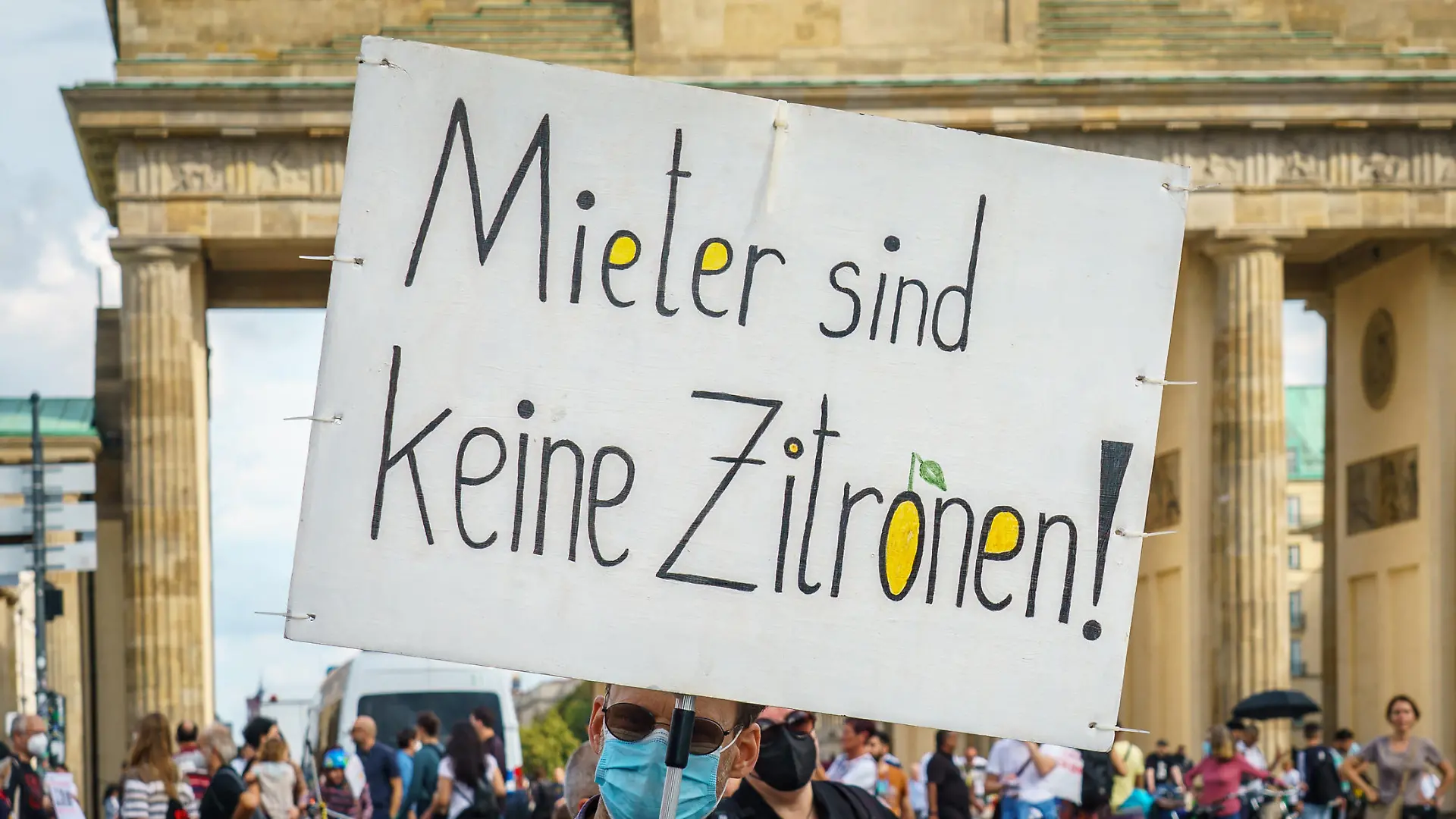 Berlin, wegen anhaltender Probleme mit den Mietpreisen demonstrieren ca. 20.000 Menschen unter dem Motto Wohnen für alle! Gemeinsam gegen hohe Mieten und Verdrängung gegen den Mietenwahnsinn und für einen Mietenstopp. Im Bild: Ein Demonstrant mit einem Schild und der Aufschrift: "Mieter sind keine Zitronen" vor dem Brandenburger Tor.