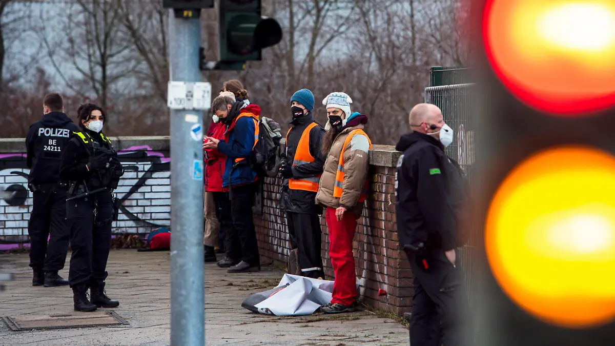 11.02.2022, Berlin: Polizeibeamte haben an der Ausfahrt Beusselstraße der Stadtautobahn 100 Klimaaktivisten festgesetzt. Aktivisten, die für mehr Klimaschutz und weniger Lebensmittelverschwendung eintreten, haben am Freitagmorgen erneut die Autobahn 100 in Berlin blockiert. Foto: Paul Zinken/dpa +++ dpa-Bildfunk +++
