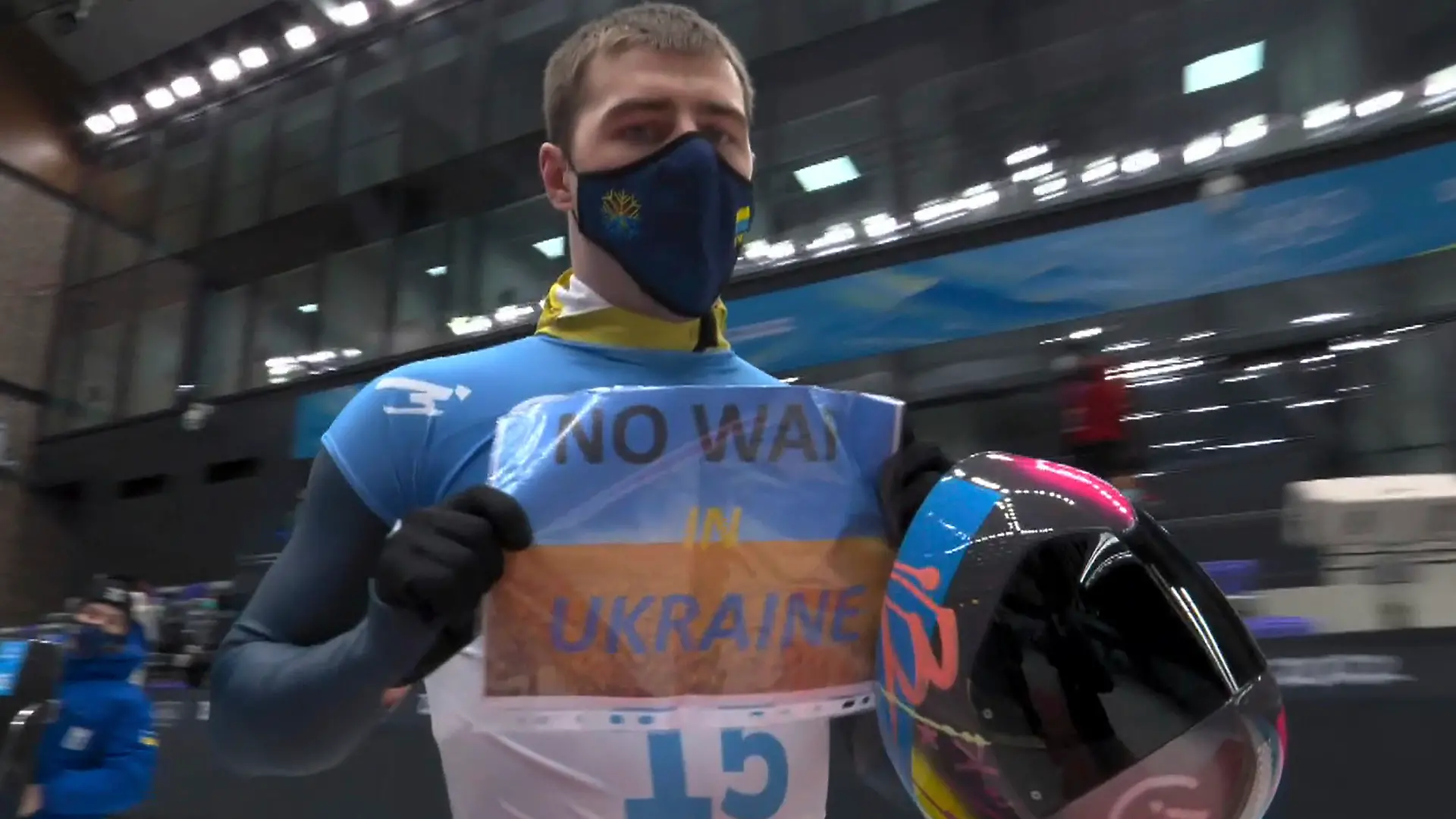 HANDOUT - 11.02.2022, China, Peking: In diesem Videobild hält der Ukrainer Wladislaw Heraskewitsch ein Schild mit der Aufschrift «Kein Krieg in der Ukraine», nachdem er einen Lauf beim Skeleton-Wettbewerb der Männer bei den Olympischen Winterspielen 2022 beendet hat (NBC via AP) (zu «Skeletonpilot protestiert bei Olympia: «Kein Krieg in der Ukraine»») Foto: Uncredited/NBC/AP/dpa - ACHTUNG: Nur zur redaktionellen Verwendung im Zusammenhang mit der aktuellen Berichterstattung innerhalb der nächsten 14 Tage und nur mit vollständiger Nennung des vorstehenden Credits +++ dpa-Bildfunk +++