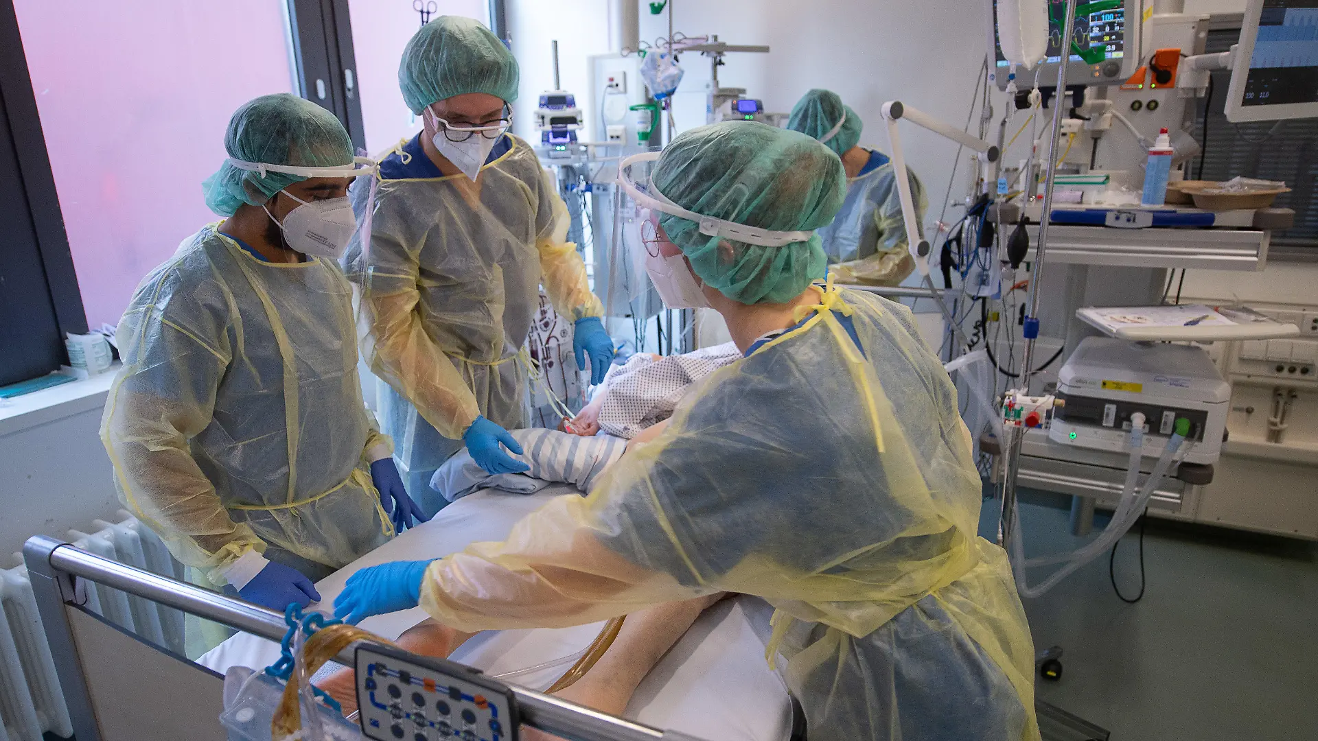 dpatopbilder - PRODUKTION - 05.01.2022, Hessen, Offenbach am Main: Pflegerinnen und Pfleger sowie eine Ärztin kümmern sich auf der Intensivstation für Corona-Patienten am Sana Klinikum Offenbach um einen Patienten. (zu dpa: «Markt ist leer gefegt» - Kampf der Kliniken gegen Pflegemangel») Foto: Sebastian Gollnow/dpa +++ dpa-Bildfunk +++