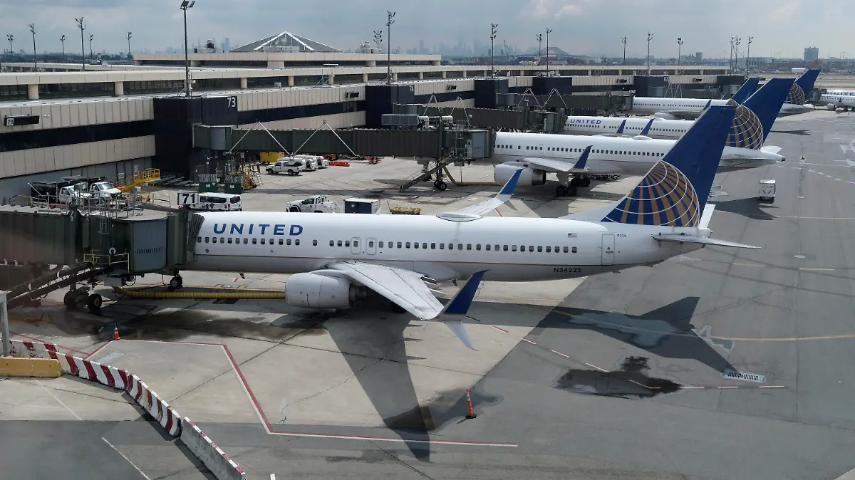 FILE - United Airlines planes are parked at gates at Newark Liberty International Airport in Newark, N.J., on July 1, 2020. United Airlines lost $646 million in the fourth quarter and said Wednesday, Jan. 19, 2021, that the current spike in COVID-19 cases will hurt its results in the March quarter.  (AP Photo/Seth Wenig, File)