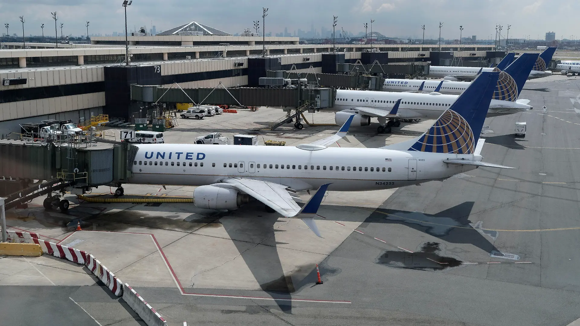 FILE - United Airlines planes are parked at gates at Newark Liberty International Airport in Newark, N.J., on July 1, 2020. United Airlines lost $646 million in the fourth quarter and said Wednesday, Jan. 19, 2021, that the current spike in COVID-19 cases will hurt its results in the March quarter.  (AP Photo/Seth Wenig, File)