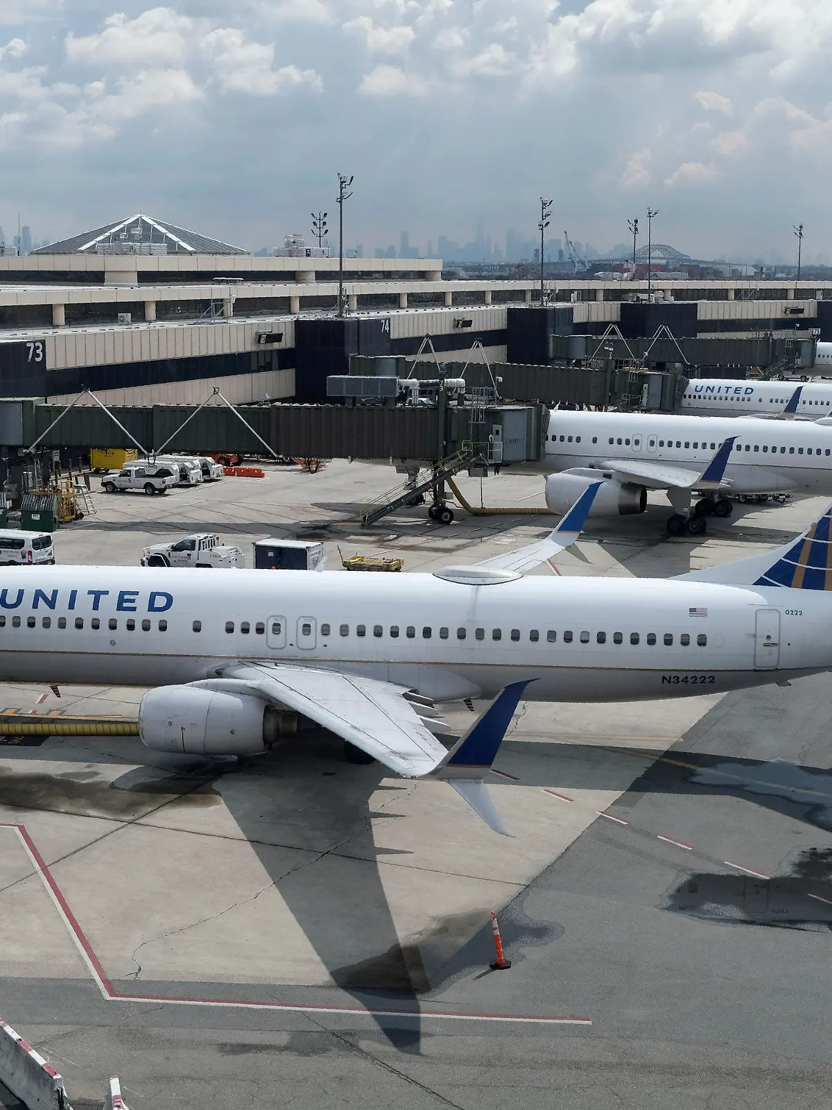 FILE - United Airlines planes are parked at gates at Newark Liberty International Airport in Newark, N.J., on July 1, 2020. United Airlines lost $646 million in the fourth quarter and said Wednesday, Jan. 19, 2021, that the current spike in COVID-19 cases will hurt its results in the March quarter.  (AP Photo/Seth Wenig, File)