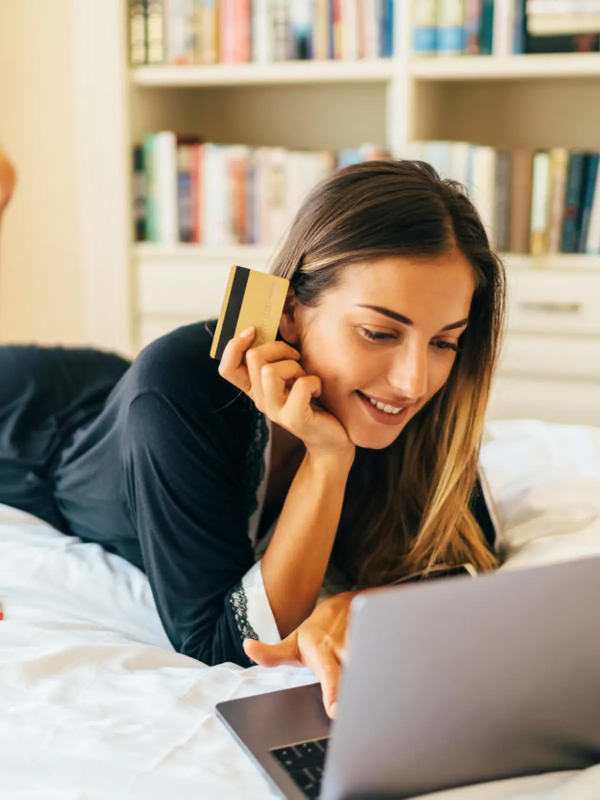 Woman in bed shopping online in the morning