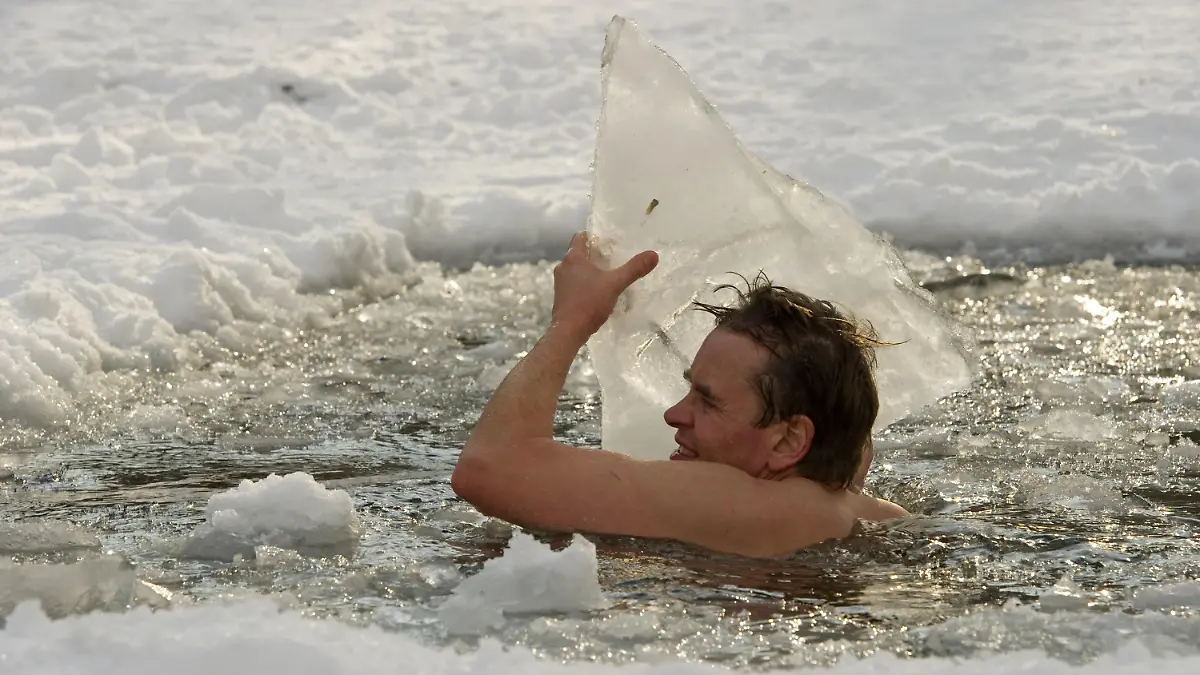 Götz badet am Sonntag (31.01.2010) bei Temperaturen um Minus sieben Grad in einem Eisloch des Schlachtensee in Berlin und wirft Eisbrocken aus dem Wasser. Seit elf Jahren sucht er das kühle Nass so oft wie möglich auf, egal bei welchen Temperaturen und gesund ist er nach eigenen Angabe immer. Foto: Arno Burgi dpa/lbn  +++(c) dpa - Bildfunk+++