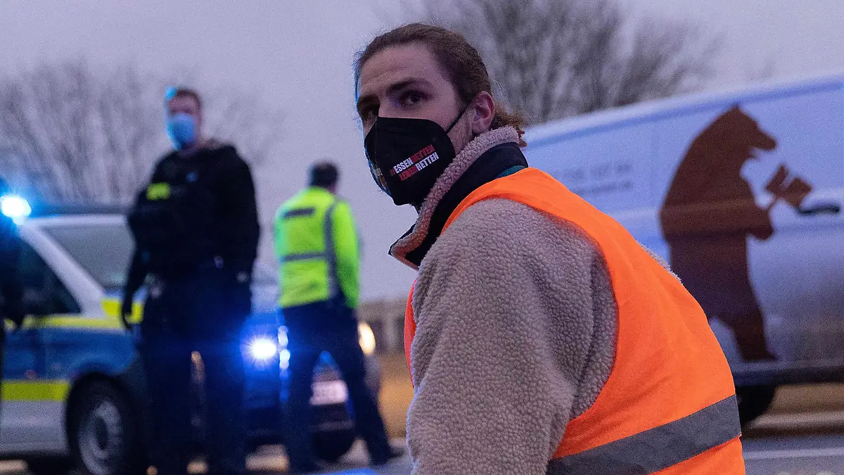 04.02.2022, Berlin: Klimaaktivisten der Gruppe ·Aufstand der letzten Generation" sitzen auf der Fahrbahn der Autobahn A100 vor der Ausfahrt Beusselstrasse, um gegen Lebensmittelverschwendung zu protestieren. Die Proteste an Zufahrten zu Autobahnen hatten vergangene Woche begonnen. Foto: Carsten Koall/dpa +++ dpa-Bildfunk +++