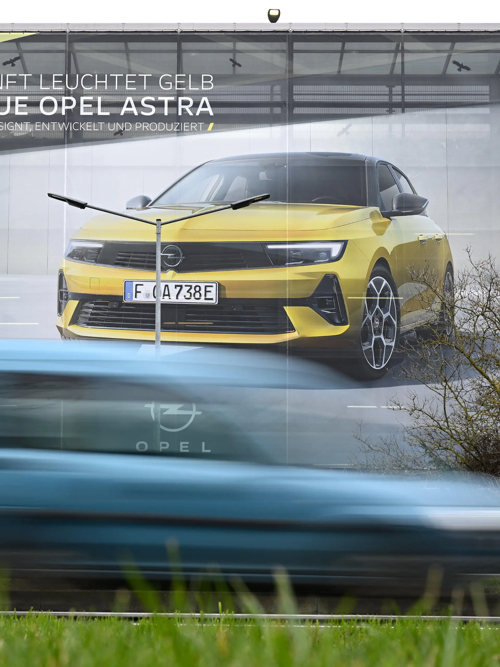 10.02.2022, Hessen, Rüsselsheim: Ein Großplakat, das einen neuen Opel Astra zeigt, ist an einem Parkhaus nahe des Opel-Werksgeländes angebracht. Im Rüsselsheimer Werk des französischen Konzerns Stellantis wurde die Serienproduktion des Volumenmodells Astra hochgefahren. Foto: Arne Dedert/dpa +++ dpa-Bildfunk +++