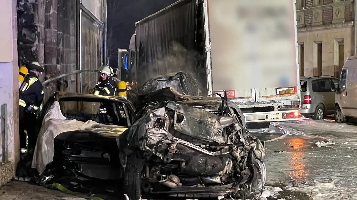 08.02.2022, Bayern, Fürth: Autowracks stehen auf einer Straße in Fürth. Ein Lkw-Fahrer hat am Abend in Fürth eine Spur der Verwüstung hinterlassen: Mit seinem Fahrzeug habe er mehrere parkende Autos gerammt, einige hätten dabei Feuer gefangen, teilte die Polizei per Twitter mit. Polizei, Feuerwehr und Rettungsdienst seien im Einsatz. Foto: Friedrich/vifogra/dpa - ACHTUNG: Aufschrift auf Lastwagen und Nummernschild aus rechtlichen Gründen gepixelt +++ dpa-Bildfunk +++