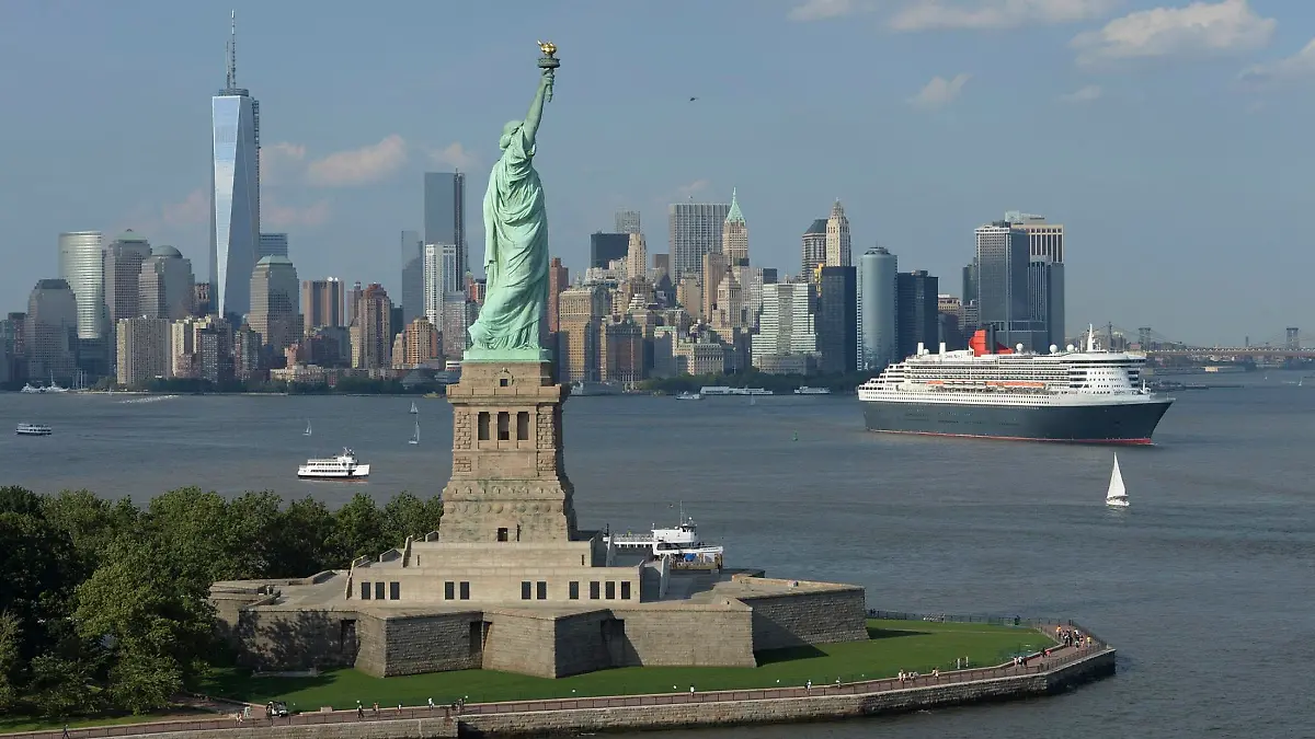 Cunard Line's flagship Queen Mary 2 is seen near the Statue of Liberty (front) and Manhattan skyline in this aerial image, as it leaves for Southampton, Britain, from the New York harbor on July 6, 2013. The ocean liner celebrated its milestone 200th transatlantic crossing since entering service in 2004. REUTERS/James Morgan/Cunard/Handout (UNTED STATES - Tags: SOCIETY TRANSPORT TRAVEL) ATTENTION EDITORS - THIS IMAGE WAS PROVIDED BY A THIRD PARTY. FOR EDITORIAL USE ONLY. NOT FOR SALE FOR MARKETING OR ADVERTISING CAMPAIGNS. NO SALES. NO ARCHIVES. THIS PICTURE IS DISTRIBUTED EXACTLY AS RECEIVED BY REUTERS, AS A SERVICE TO CLIENTS. MANDATORY CREDIT