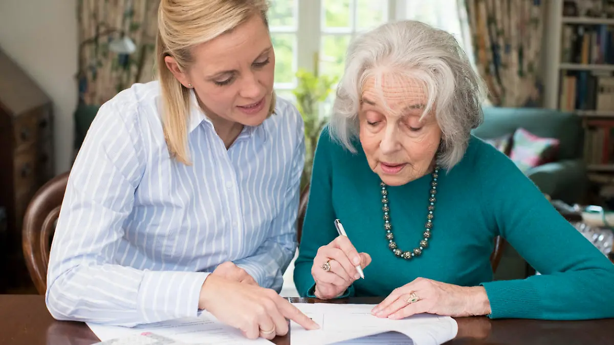 Woman Helping Senior Neighbor With Paperwork