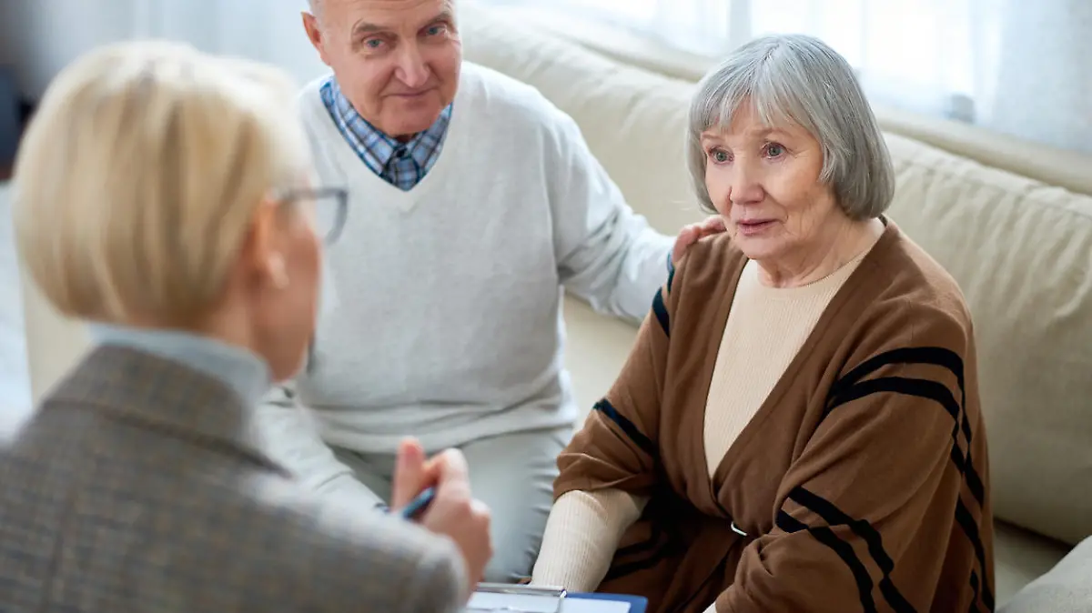 Anonymous therapist having meeting with elderly patients in nursing home giving consultation.