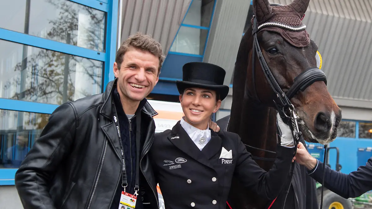ARCHIV - 16.11.2019, Baden-Württemberg, Stuttgart: Pferdesport, 35. Stuttgart German Masters, Dressur, Qualifikation zum Master: Dressurreiterin Lisa Müller steht zwischen ihrem Pferd Stand by me und ihrem Mann Thomas Müller, Fußballspieler des FC Bayern. (zu: Familie Müller zwischen Sport und Zucht: «Von den Socken gehauen») Foto: Sebastian Gollnow/dpa +++ dpa-Bildfunk +++