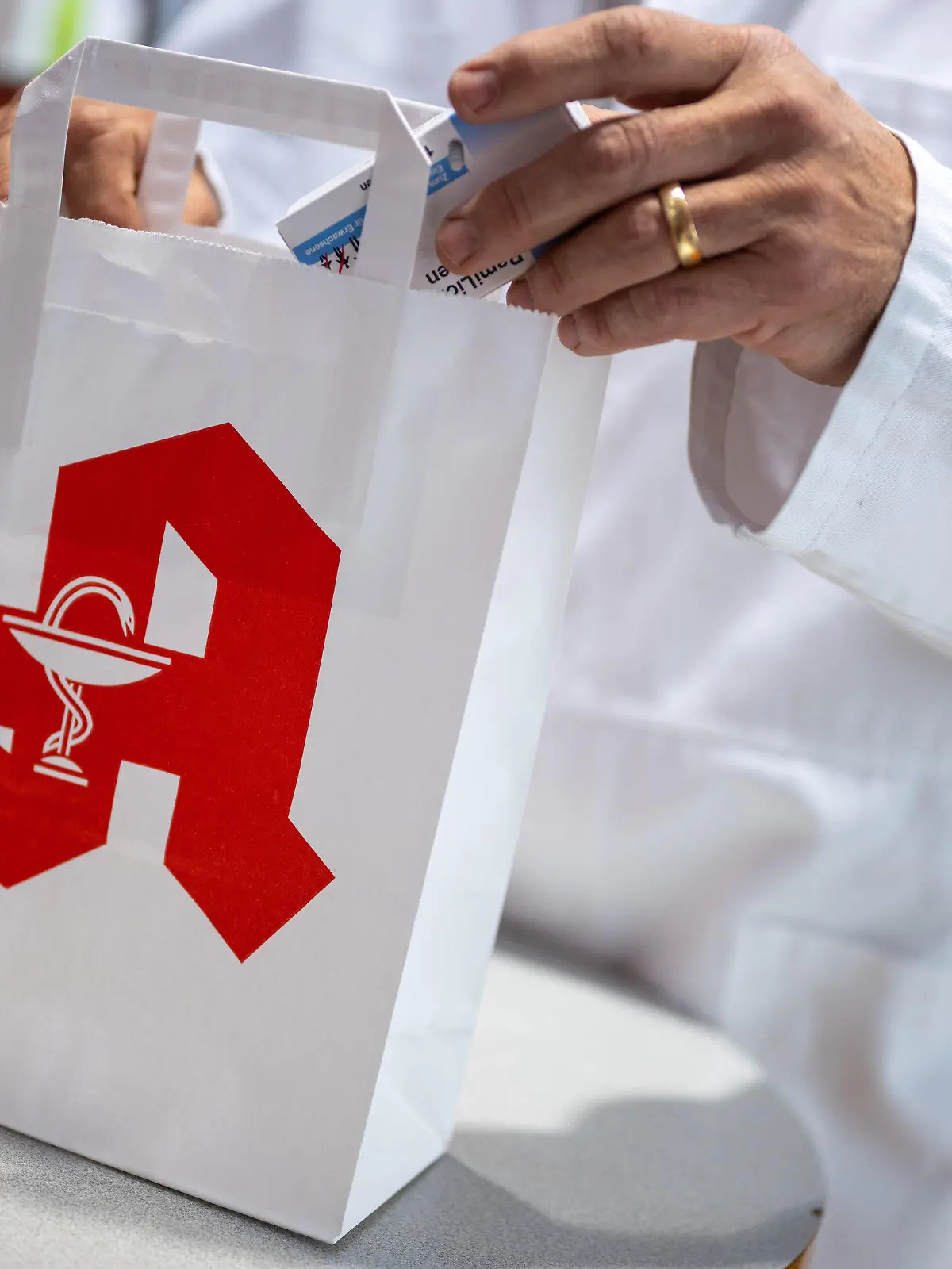 ARCHIV - 05.06.2023, Berlin: Ein Apotheker legt in einer Apotheke eine Packung mit Tabletten in eine Papiertasche mit Apotheken-Logo. (zu dpa «Viele Apotheken wollen am Mittwoch aus Protest geschlossen bleiben») Foto: Monika Skolimowska/dpa +++ dpa-Bildfunk +++