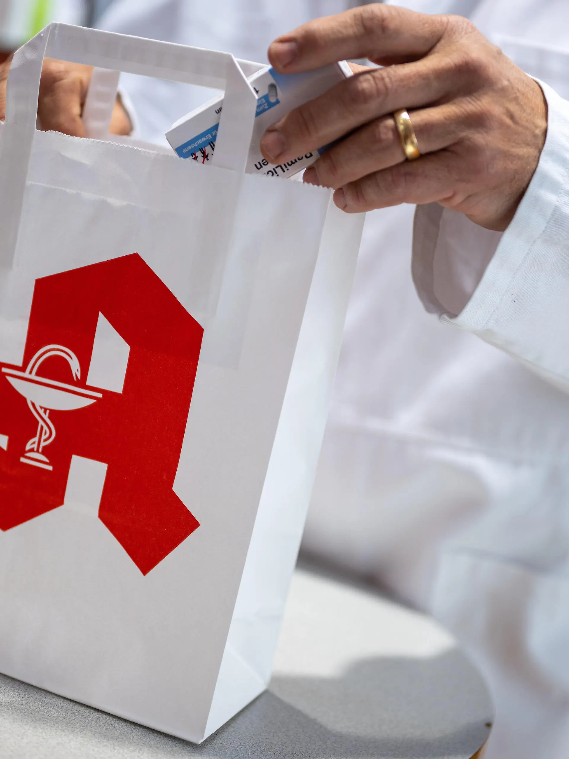 ARCHIV - 05.06.2023, Berlin: Ein Apotheker legt in einer Apotheke eine Packung mit Tabletten in eine Papiertasche mit Apotheken-Logo. (zu dpa «Viele Apotheken wollen am Mittwoch aus Protest geschlossen bleiben») Foto: Monika Skolimowska/dpa +++ dpa-Bildfunk +++