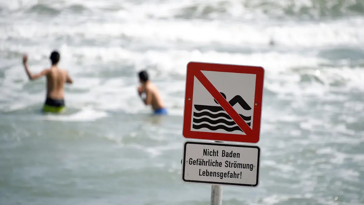 Ein Schild "Nicht Baden Gefährliche Strömung Lebensgefahr!" warnt am 22.07.2014 am Ostseestrand von Timmendorfer Strand (Schleswig-Holstein) die Besucher. Wegen starker Strömung herrscht hier ein Badeverbot. Nach den tödlichen Badeunfällen an der Ostsee hat die Polizei an die Badegäste appelliert, rote Flaggen der DLRG und direkt am Wasser aufgestellte Hinweisschilder zu beachten. Foto: Carsten Rehder/dpa (Zu dpa "Polizei mahnt Badegäste nach Unfällen zur Besonnenheit" vom 22.07.2014) +++(c) dpa - Bildfunk+++