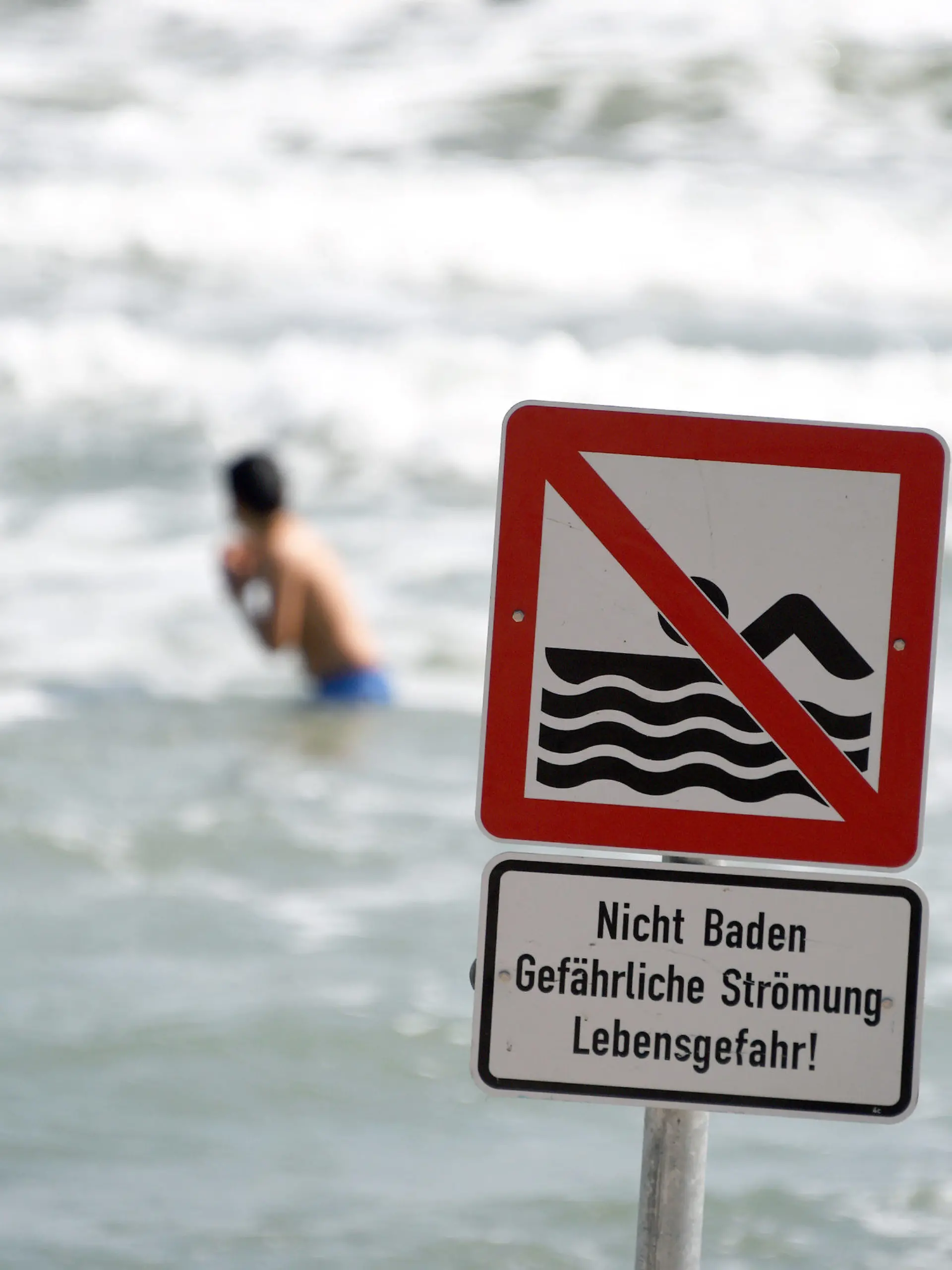 Ein Schild "Nicht Baden Gefährliche Strömung Lebensgefahr!" warnt am 22.07.2014 am Ostseestrand von Timmendorfer Strand (Schleswig-Holstein) die Besucher. Wegen starker Strömung herrscht hier ein Badeverbot. Nach den tödlichen Badeunfällen an der Ostsee hat die Polizei an die Badegäste appelliert, rote Flaggen der DLRG und direkt am Wasser aufgestellte Hinweisschilder zu beachten. Foto: Carsten Rehder/dpa (Zu dpa "Polizei mahnt Badegäste nach Unfällen zur Besonnenheit" vom 22.07.2014) +++(c) dpa - Bildfunk+++