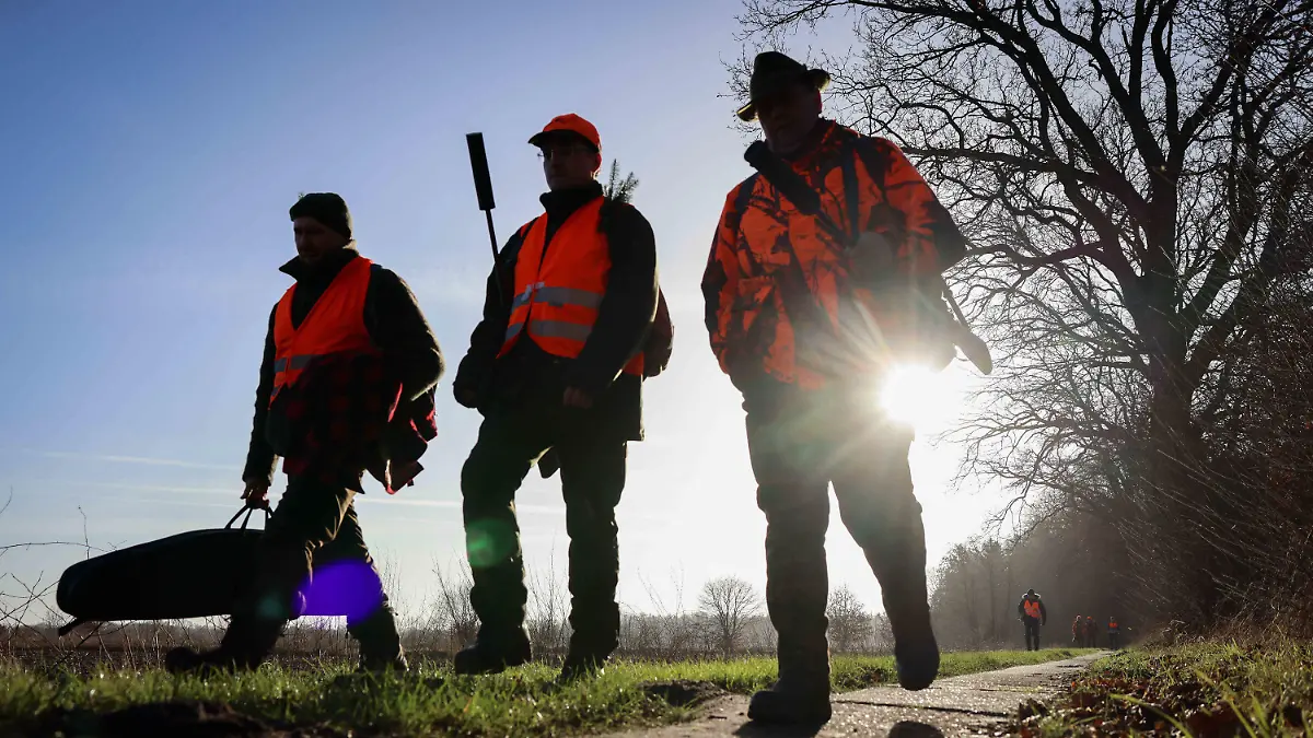 15.01.2022, Schleswig-Holstein, Drage: Ein Gruppe Jäger geht nach einer Drückjagd auf Rehwild im Forst Halloh zurück zum Parkplatz. Wild und Wald gehören zusammen. Aber wo der Wildbestand zu groß wird, gefährdet er die gewünschte Naturverjüngung des Waldes. Aufgabe der Jäger ist die Regulierung. (zu dpa "Nicht jede Jagd bringt eine reiche Strecke") Foto: Christian Charisius/dpa +++ dpa-Bildfunk +++