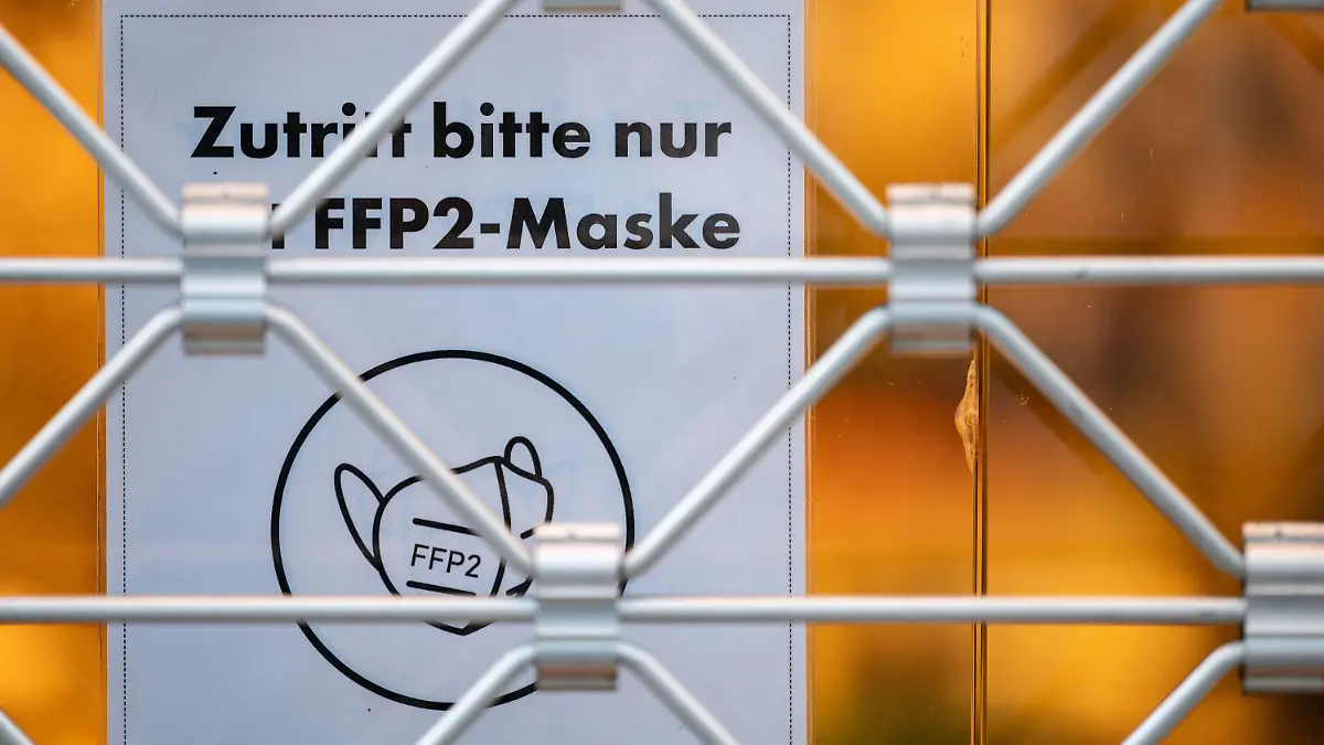 12.01.2022, Baden-Württemberg, Stuttgart: Ein Schild auf der Eingangstür eines Einzelhandelsgeschäfts weist auf das Tragen einer FFP2-Maske hin. Die Menschen in Baden-Württemberg müssen in Geschäften FFP2-Masken tragen. Das sieht die neue Corona-Verordnung der Landesregierung vor, mit der die Ausbreitung der besonders ansteckenden Omikron-Variante des Virus gebremst werden soll. Foto: Marijan Murat/dpa +++ dpa-Bildfunk +++