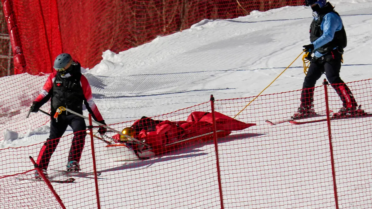 Paramedics carry down Dominik Schwaiger, of Germany, after he fell during the men's downhill at the 2022 Winter Olympics, Monday, Feb. 7, 2022, in the Yanqing district of Beijing.(AP Photo/Luca Bruno)