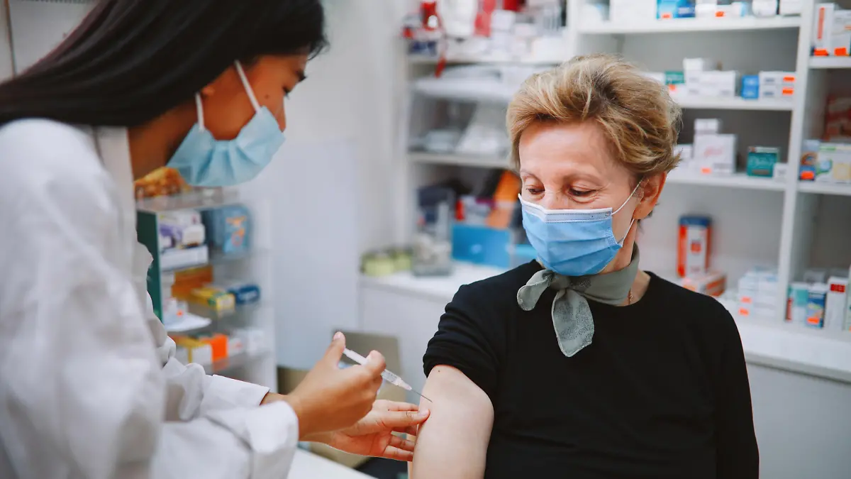 Asian nurse giving flu vaccine to a senior patient in the hospital during the global coronavirus covid-19 pandemic.
