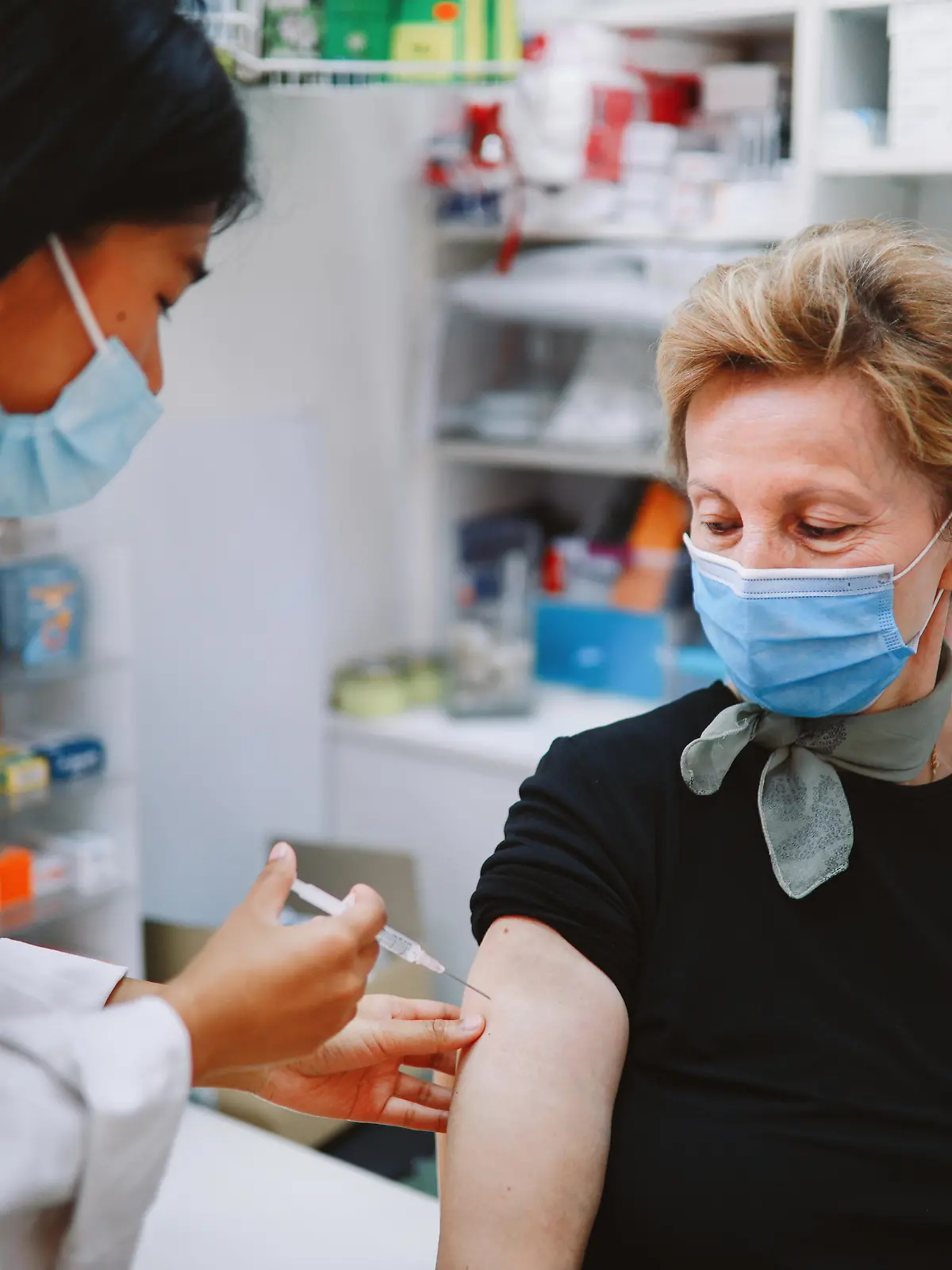 Asian nurse giving flu vaccine to a senior patient in the hospital during the global coronavirus covid-19 pandemic.