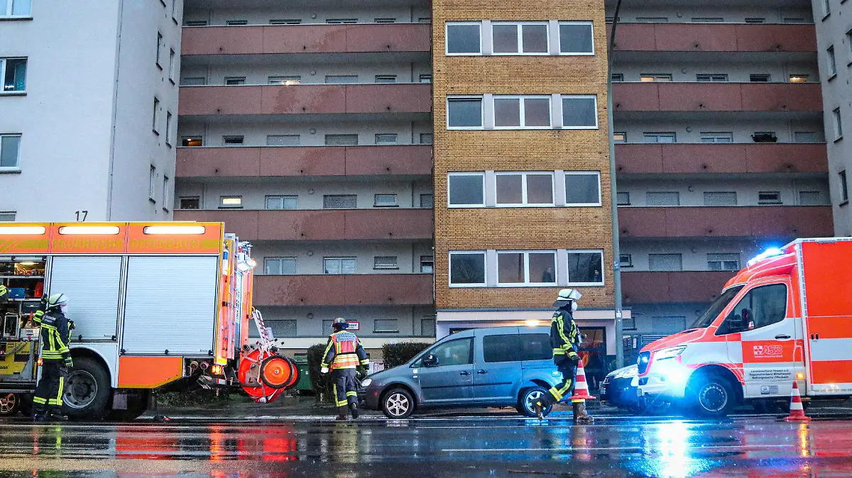 06.02.2022, Hessen, Offenbach: Feuerwehrleute stehen vor einem Wohnblock in Offenbach. Durch eine Explosion in einer Wohnung sind am Sonntagnachmittag eine Frau und ihre beiden Kinder leicht verletzt worden. Die Mutter und die beiden Kleinkinder seien zur Behandlung ins Krankenhaus gebracht worden, teilte die Feuerwehr am Sonntagabend mit. Die Ursache der Explosion war zunächst unklar. Foto: Marwin Stephan/5vision.media /dpa +++ dpa-Bildfunk +++