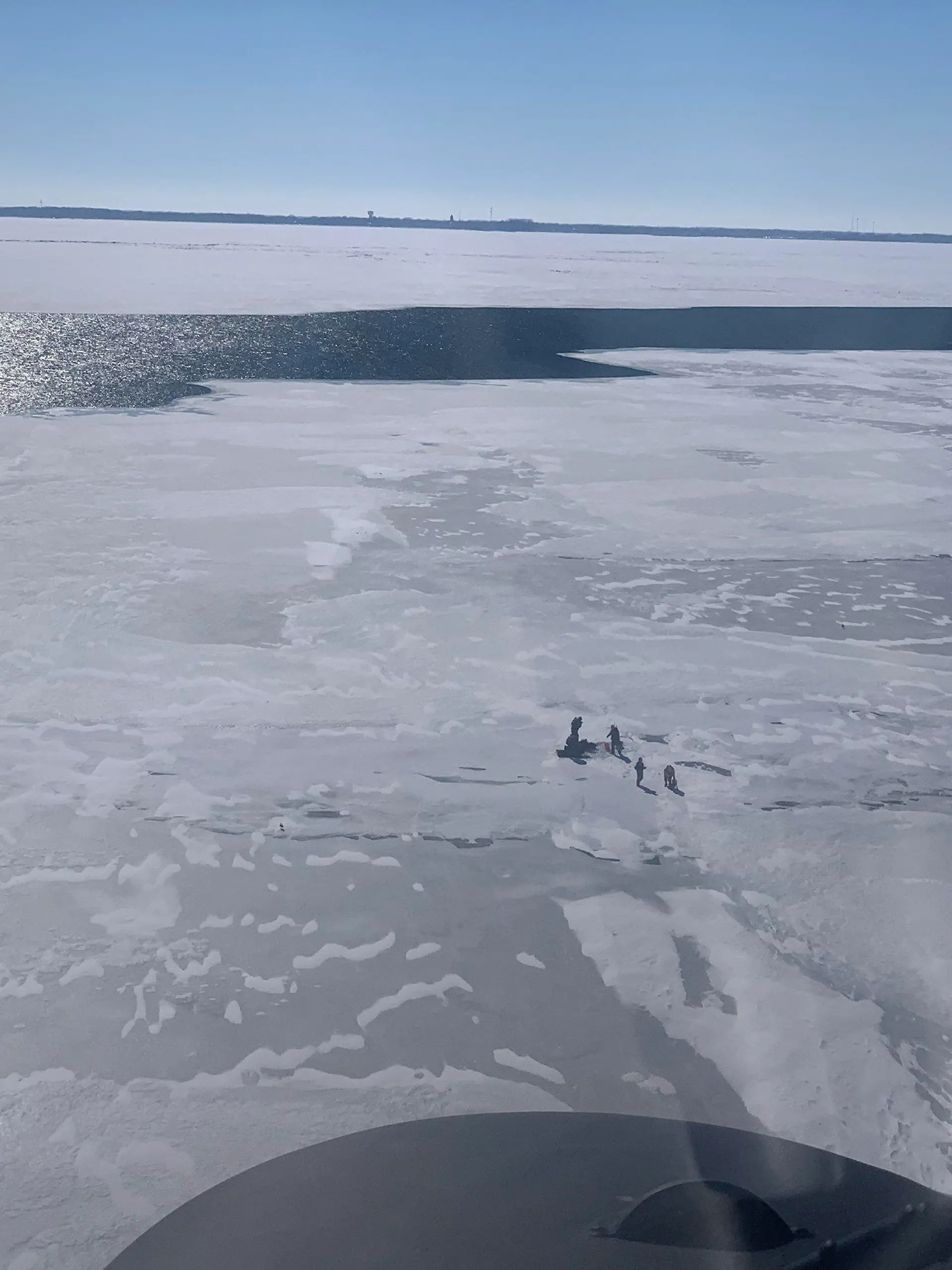 HANDOUT - 07.02.2022, USA, Catawba Island: Die aus einem Hubschrauber der US-Küstenwache fotografierte Aufnahme zeigt auf einer Eisscholle gestrandete Menschen auf einem der fünf Großen Seen ("Great Lakes") im Nordosten der USA. Die US-Küstenwache konnte 18 Menschen von der treibenden Eisscholle retten, die sich kurz zuvor auf dem See an der Grenze zu Kanada gelöst hatte. Foto: United States Coast Guard/dpa - ACHTUNG: Nur zur redaktionellen Verwendung im Zusammenhang mit der aktuellen Berichterstattung und nur mit vollständiger Nennung des vorstehenden Credits +++ dpa-Bildfunk +++