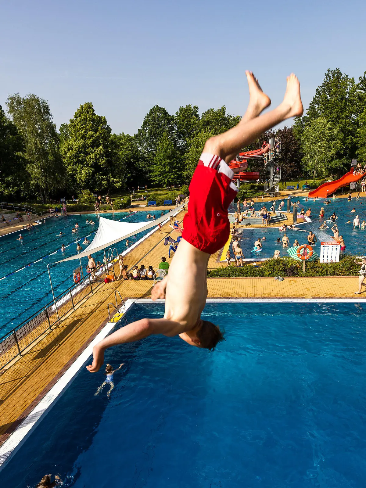 18.06.2022, Brandenburg, Forst: Im Freibad in Forst (Lausitz) springt ein Badegast bei etwa 35 Grad Celsius im Schatten von der 5-meter-Plattform des Sprungturms ins Becken. Foto: Frank Hammerschmidt/dpa +++ dpa-Bildfunk +++