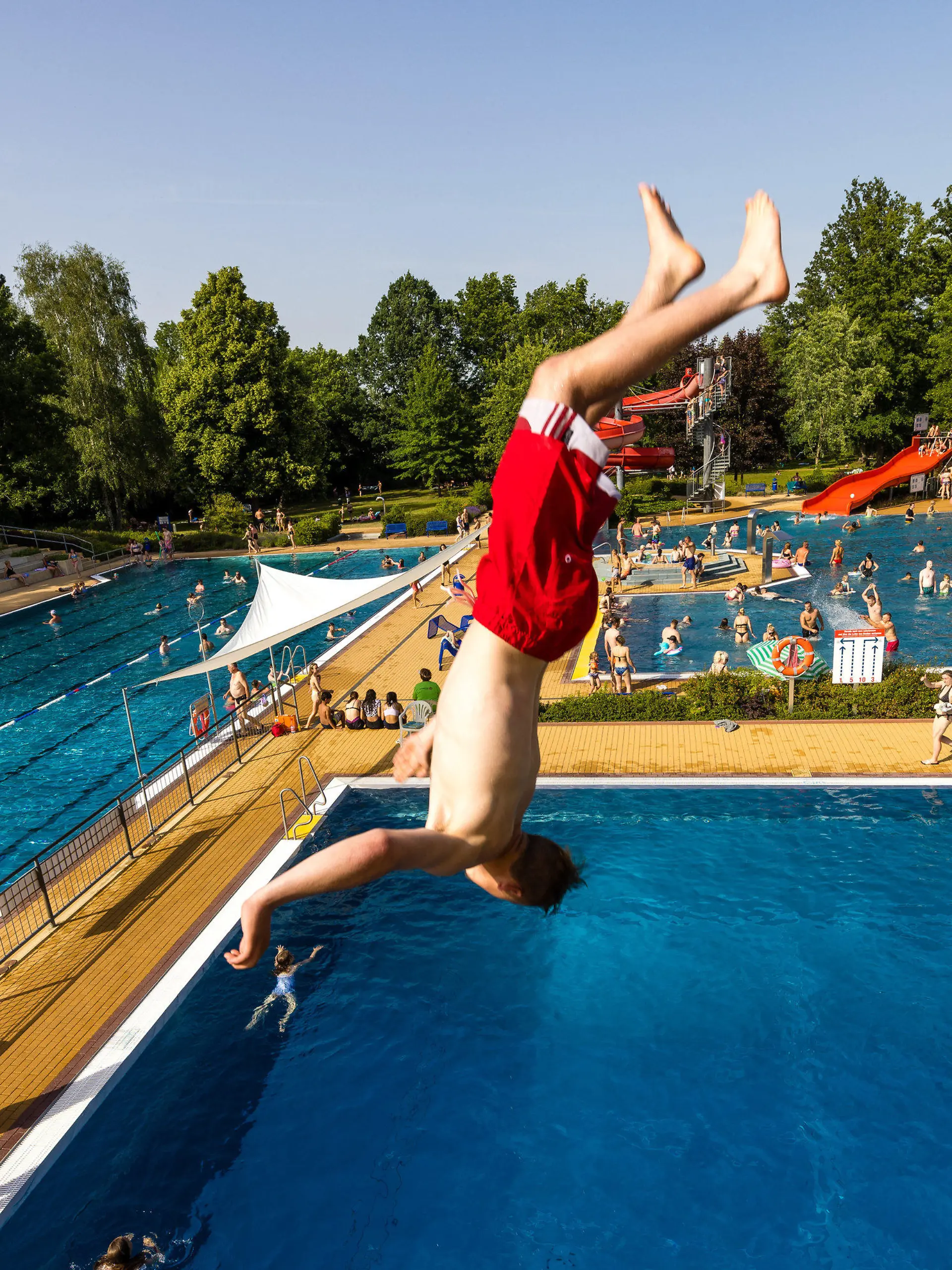 18.06.2022, Brandenburg, Forst: Im Freibad in Forst (Lausitz) springt ein Badegast bei etwa 35 Grad Celsius im Schatten von der 5-meter-Plattform des Sprungturms ins Becken. Foto: Frank Hammerschmidt/dpa +++ dpa-Bildfunk +++