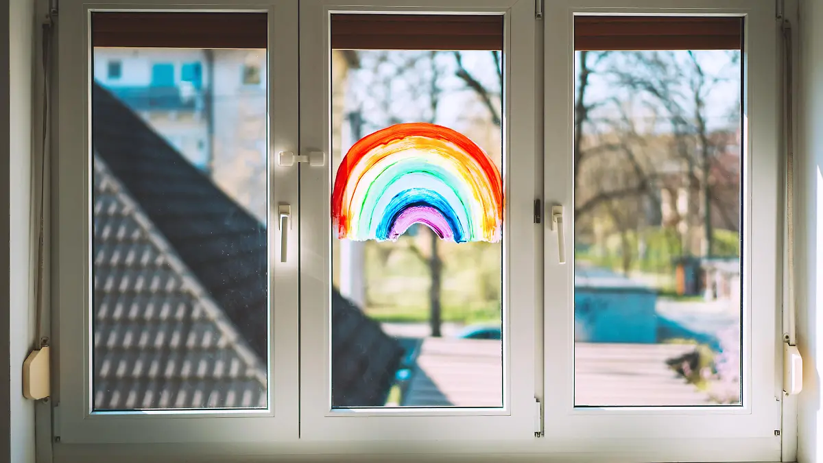 Close-up photo of painting rainbow on window. Rainbow painted with paints on glass is a symbol for many meanings.