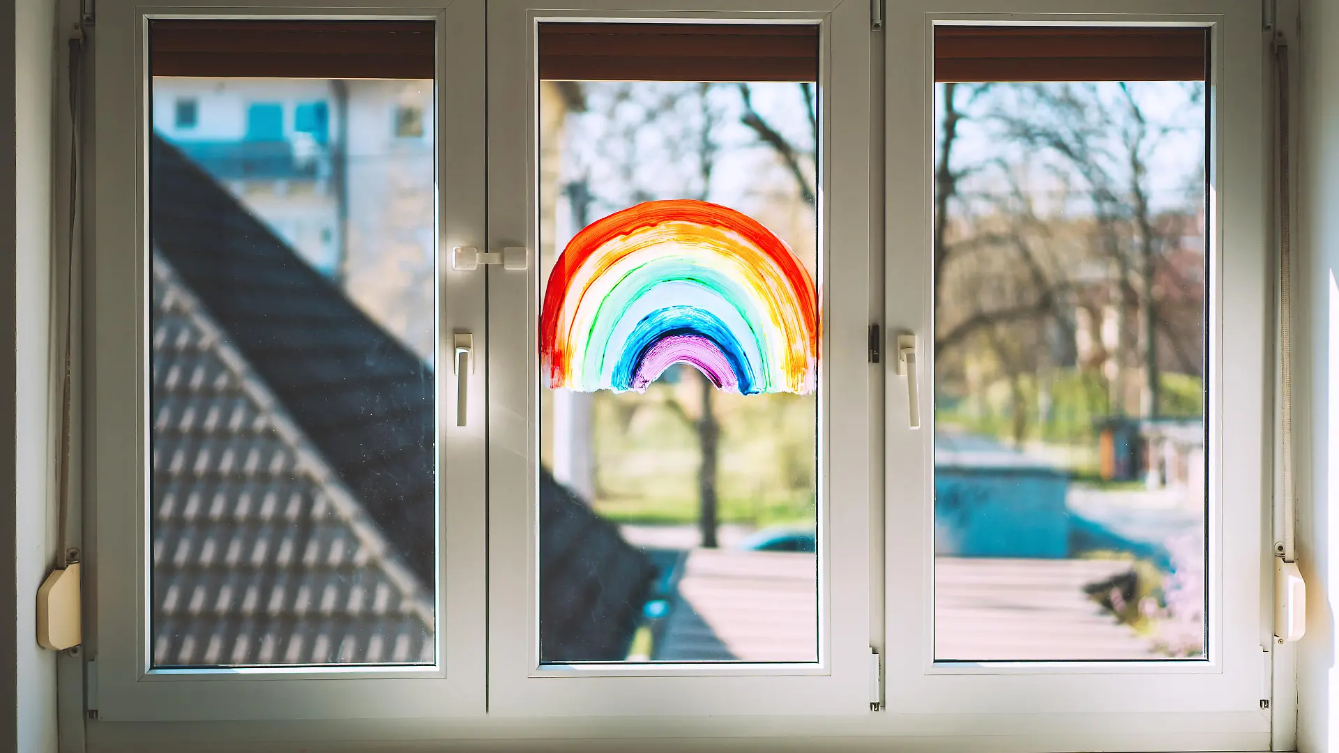 Close-up photo of painting rainbow on window. Rainbow painted with paints on glass is a symbol for many meanings.