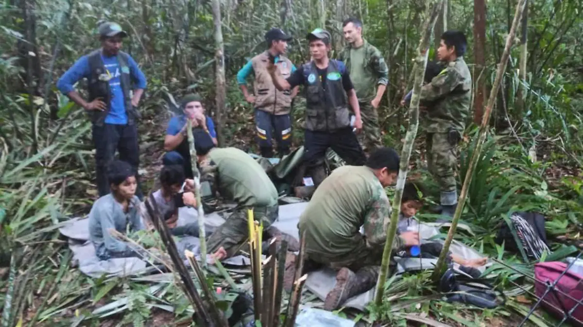 HANDOUT - 09.06.2023, Kolumbien, Solano-Dschungel: Auf diesem von der Pressestelle der kolumbianischen Streitkräfte veröffentlichten Foto kümmern sich Soldaten und indigene Männer um die vier Geschwister, die nach einem tödlichen Flugzeugabsturz vermisst wurden, im Dschungel von Solano im kolumbianischen Bundesstaat Caqueta. Über einen Monat nach dem Absturz eines Kleinflugzeugs im kolumbianischen Regenwald sind alle vier vermissten Kinder lebend gefunden worden. Das teilte der kolumbianische Präsident Petro am Freitag auf Twitter mit. Die Geschwister - 13, 9, 4 und 1 Jahr alt - waren am 1. Mai verunglückt. (zu dpa «Kinder nach Flugzeugabsturz im Regenwald lebend gefunden») Foto: Uncredited/Colombia's Armed Force Press Office/AP/dpa - ACHTUNG: Nur zur redaktionellen Verwendung und nur mit vollständiger Nennung des vorstehenden Credits +++ dpa-Bildfunk +++