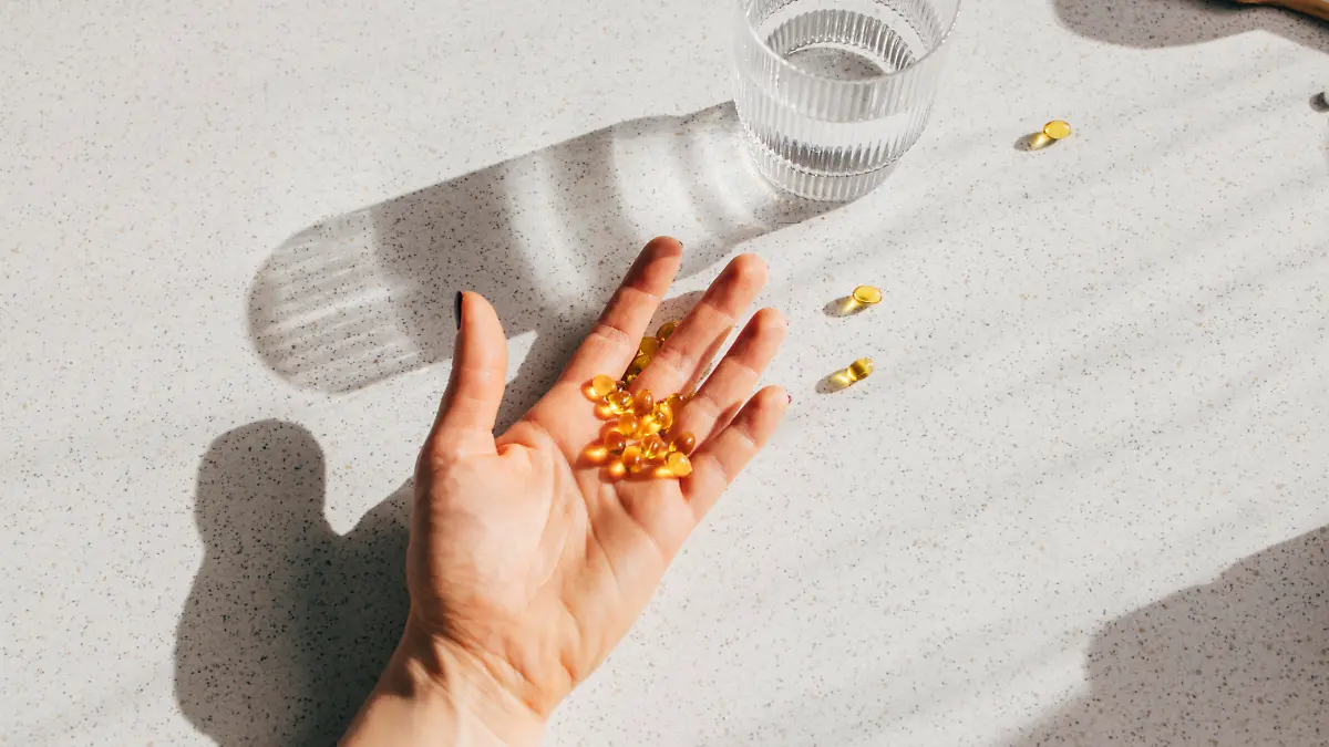 A high angle shot of an unrecognizable person's hand holding a bunch of vitamin D pills.