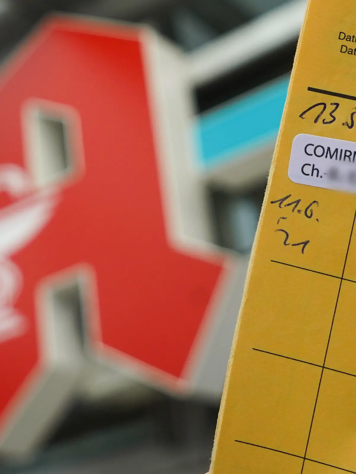 ARCHIV - 14.06.2021, Berlin: ILLUSTRATION - Ein Impfpass, auf dem zwei Corona-Impfungen mit Comirnaty dokumentiert sind, wird vor das Logo einer Pankower Apotheke gehalten (Illustration). (zu dpa «Corona-Impfungen nur in den wenigsten Thüringer Apotheken möglich») Foto: Jörg Carstensen/dpa - ACHTUNG: Die Chargennummern des Impfstoffs wurden aus rechtlichen Gründen gepixelt +++ dpa-Bildfunk +++