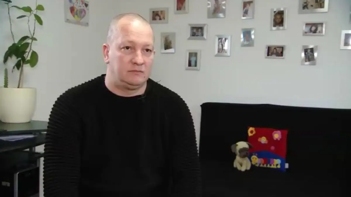 Screenshot eines Mannes, der scheinbar in seiner Wohnung ein Interview gibt